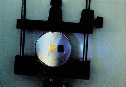 가시광선 발광이 불가능한 것으로 믿어졌던 실리콘 반도체로부터 오렌지색의 빛을 얻어내는 모습. 원판 위에 놓인 두조각의 실리콘 중 왼쪽은 빛을 내는 실리콘, 오른쪽은 처리되지 않은 모통실리콘. 이 결과로 인해 전자소자로만 쓰이던 실리콘이 광자소자로도 쓰일 가능성을 열어주게 되었다.