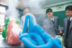 과산화수소와 요오드화칼륨 을 물비누와 섞어 만든 거대 한 거품을 보며 즐거워하는 청 솔중학교 과학반 학생.