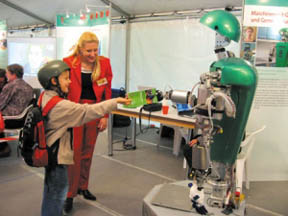 로봇 아마르가 어린이에게 책을 건네주고 있다.