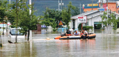 이산화탄소는 이상기후를 일으키는 지구온난화의 주범으로 여겨진다. 사진은 2006년 여름 폭우로 마을이 침수돼 보트를 타고 대피하는 경기도 안성시 주민의 모습.