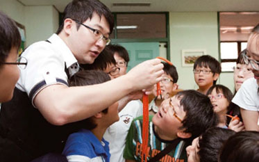 고난도의 세 줄 마술을 선보이는 박근영 마술사와 비밀을 캐기 위해 유심히 관찰하는 학생들.