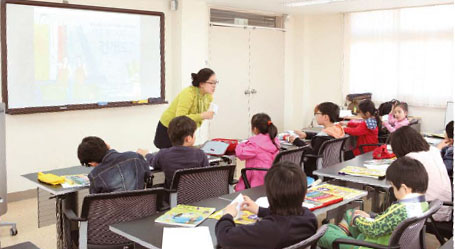 이번 수업을 진행한 염지현 기자가 학생들에게 A4용지를 이용한 삼각기둥 만들기를 설명하고 있다.